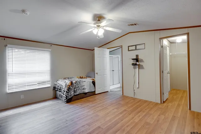 a very nice looking room with wooden floor and a ceiling fan