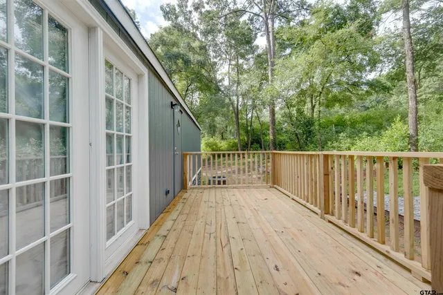a view of a wooden deck and a yard from balcony
