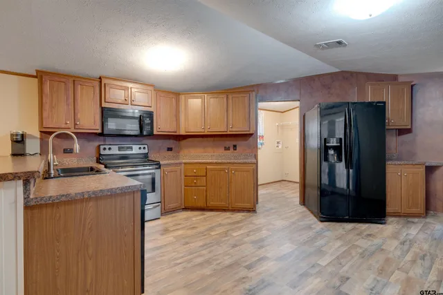 a kitchen with a refrigerator sink and wooden floor