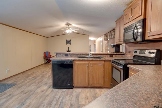 a kitchen with stainless steel appliances granite countertop a stove a sink and a microwave