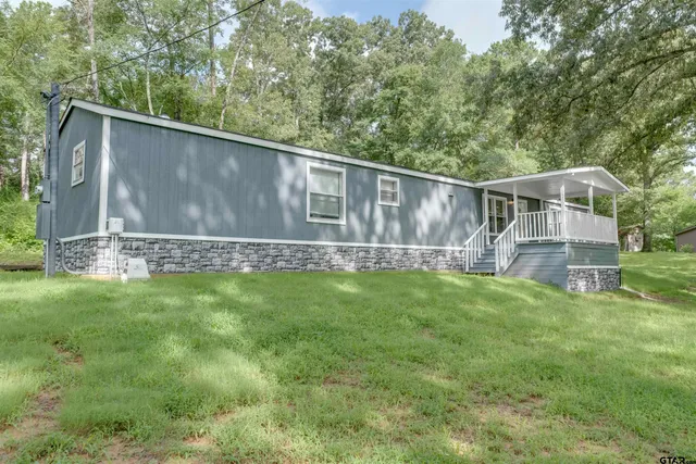 a backyard with wooden fence and large trees