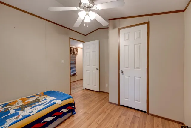 a bedroom with a bed and wooden floor