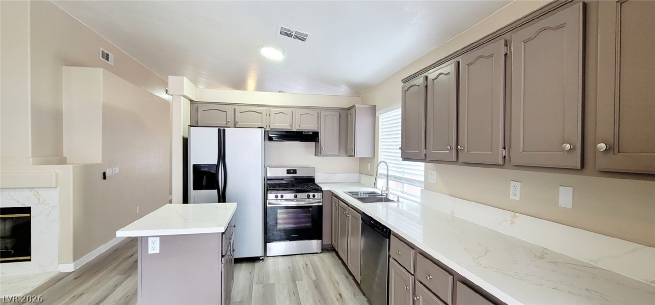 19 Rue De Parc Henderson, NV 89074 - Photo 6 of 23 Gleaming stone countertops and classic cabinetry elevate this open kitchen layout.