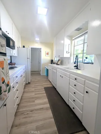 a large white kitchen with stainless steel appliances