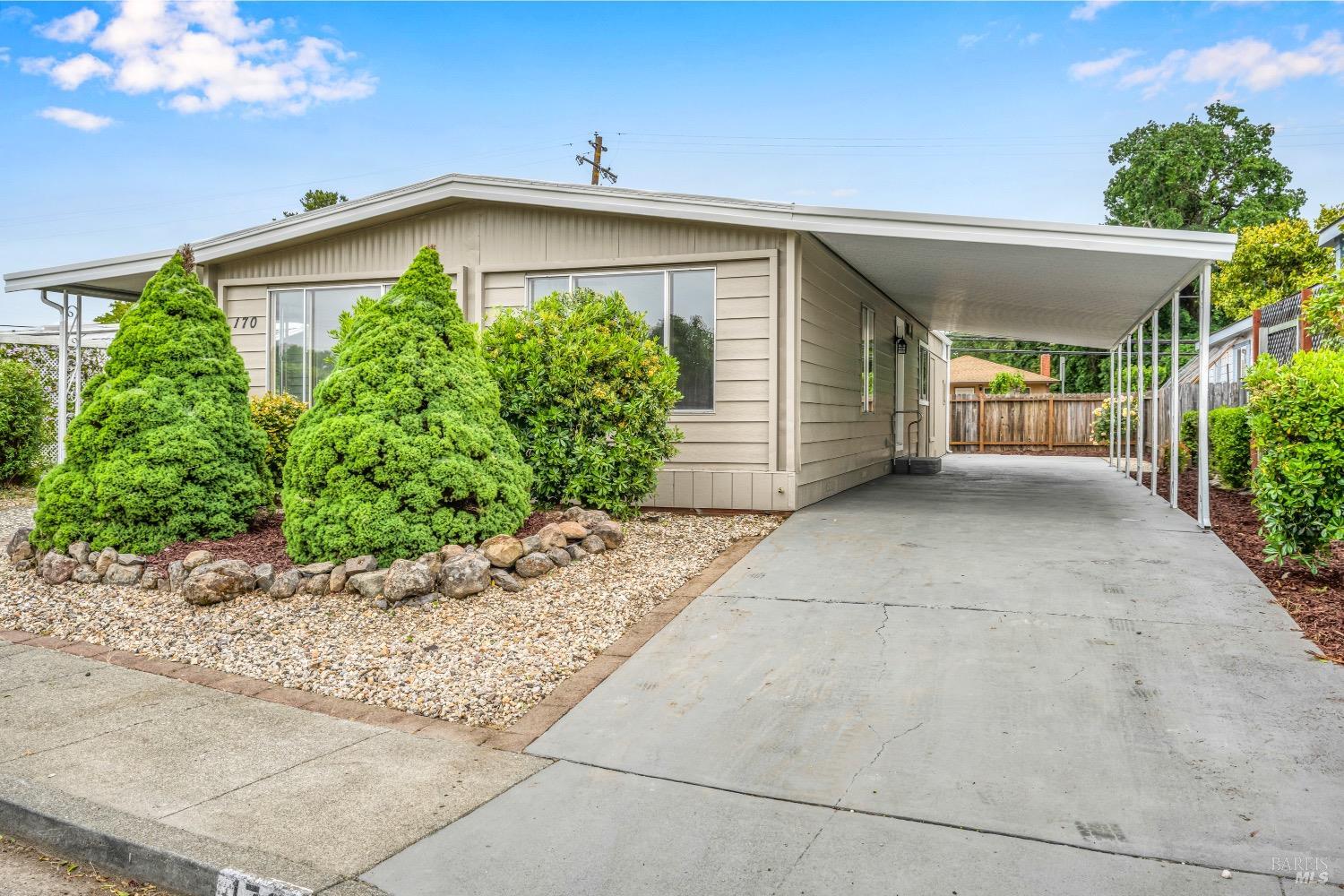 a view of a house with a yard and potted plants