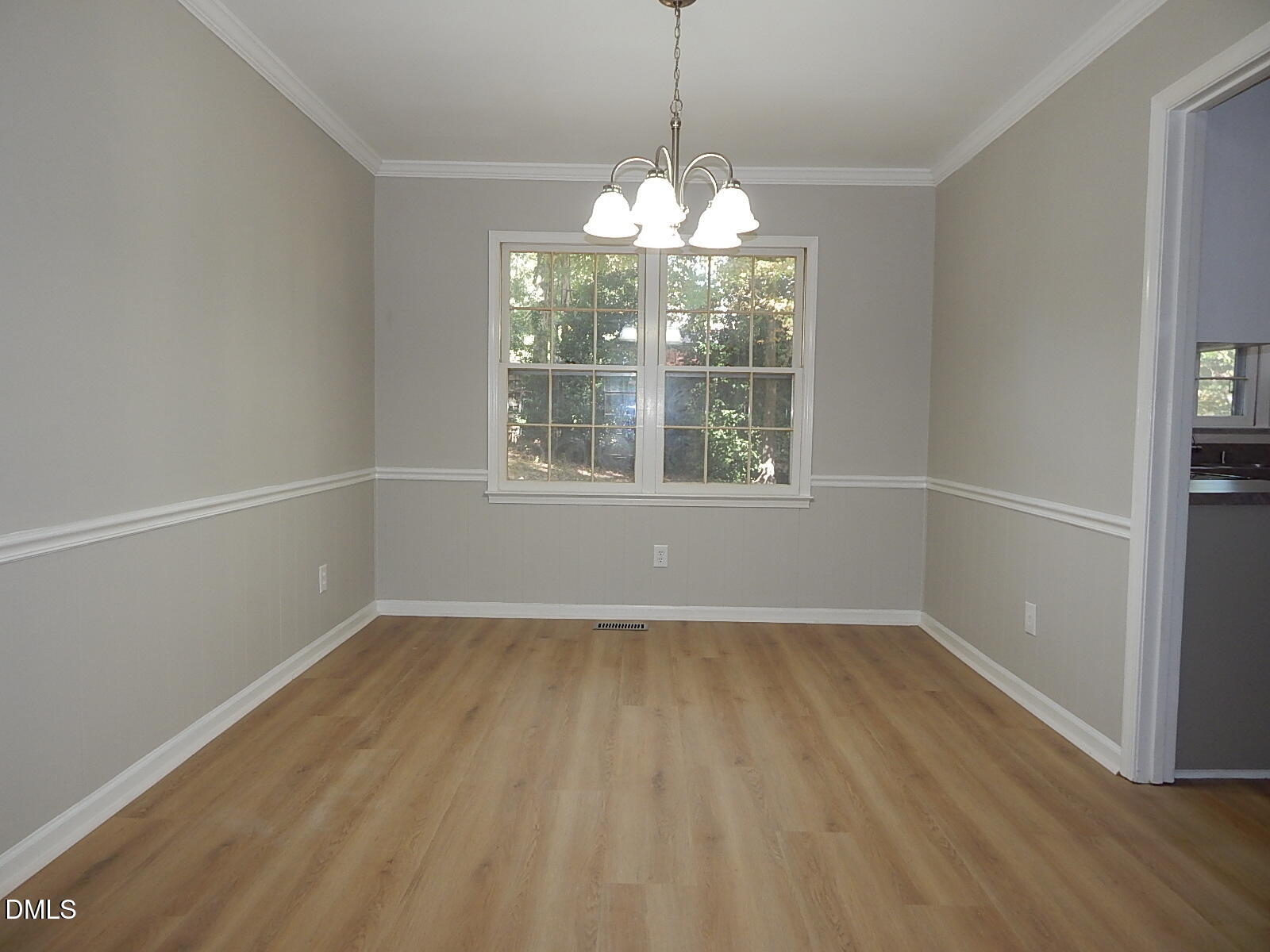 6408 Shadow Court Raleigh, NC 27613 - Photo 14 of 35 a view of an empty room with wooden floor and a window