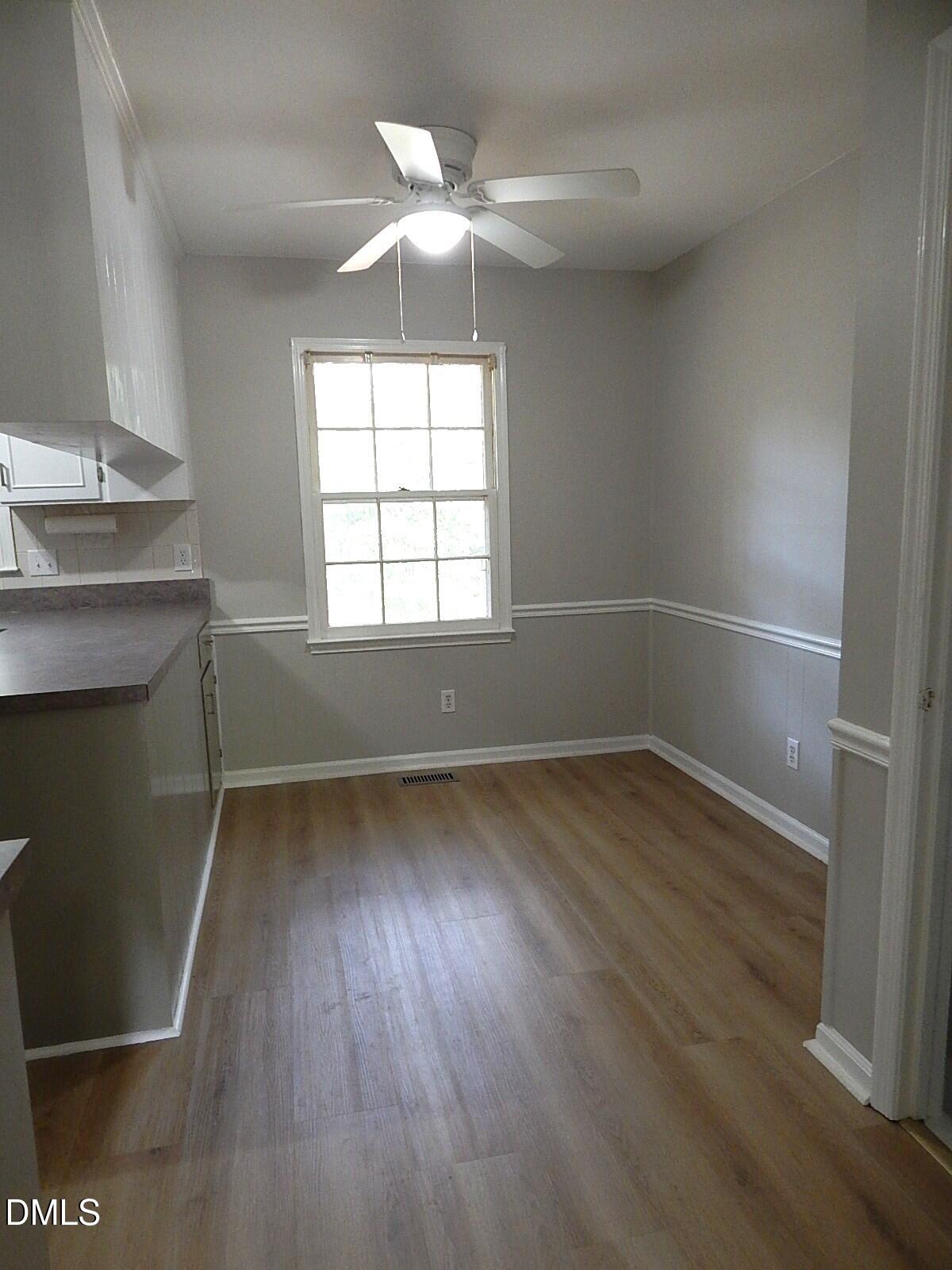 6408 Shadow Court Raleigh, NC 27613 - Photo 18 of 35 an empty room with wooden floor and windows