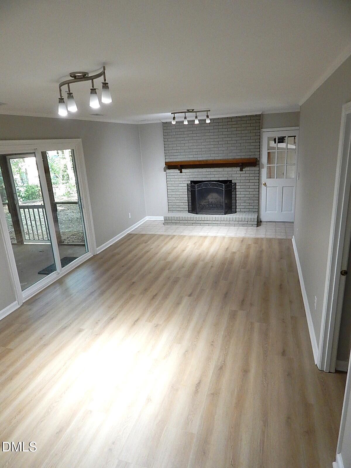 6408 Shadow Court Raleigh, NC 27613 - Photo 29 of 35 an empty room with wooden floor fireplace and windows