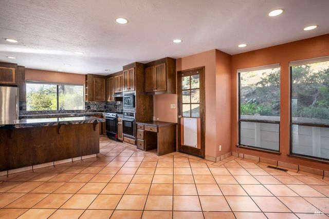 a kitchen with stainless steel appliances granite countertop a refrigerator and a sink
