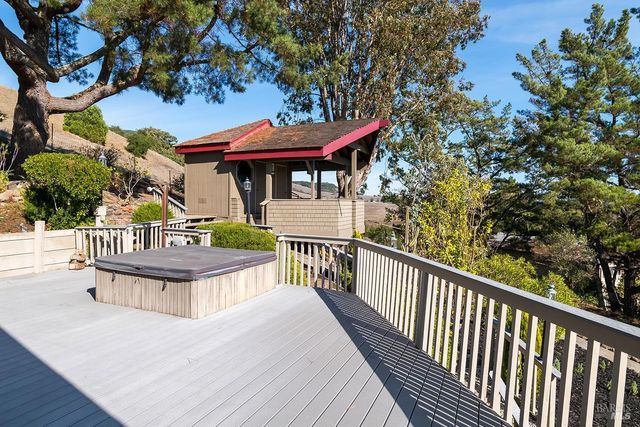 a view of a deck with a table and chairs under an umbrella with wooden fence