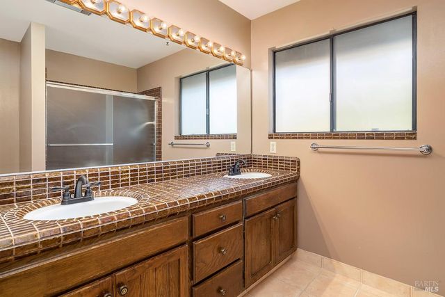 a bathroom with a granite countertop toilet and sink