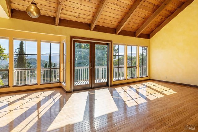 a view of a room with wooden floor and windows