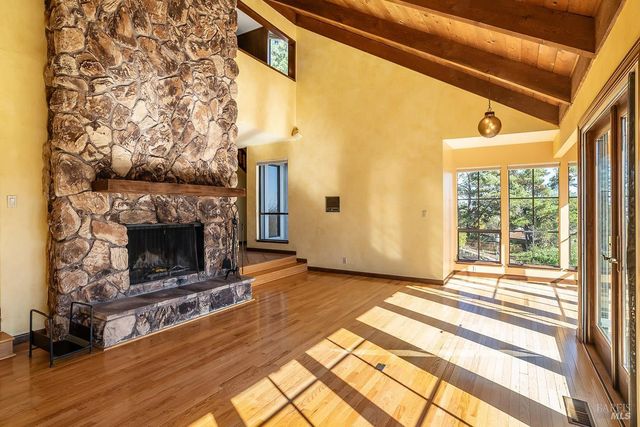a view of a livingroom with wooden floor and a fireplace