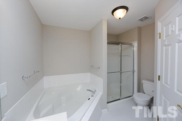 5422 Echo Ridge Road Raleigh, NC 27612 - Photo 11 of 14 a white bath tub sitting next to a toilet