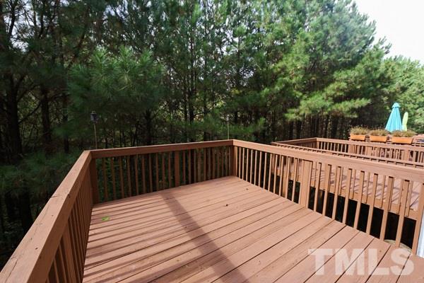 5422 Echo Ridge Road Raleigh, NC 27612 - Photo 12 of 14 a balcony with wooden floor and trees in the back