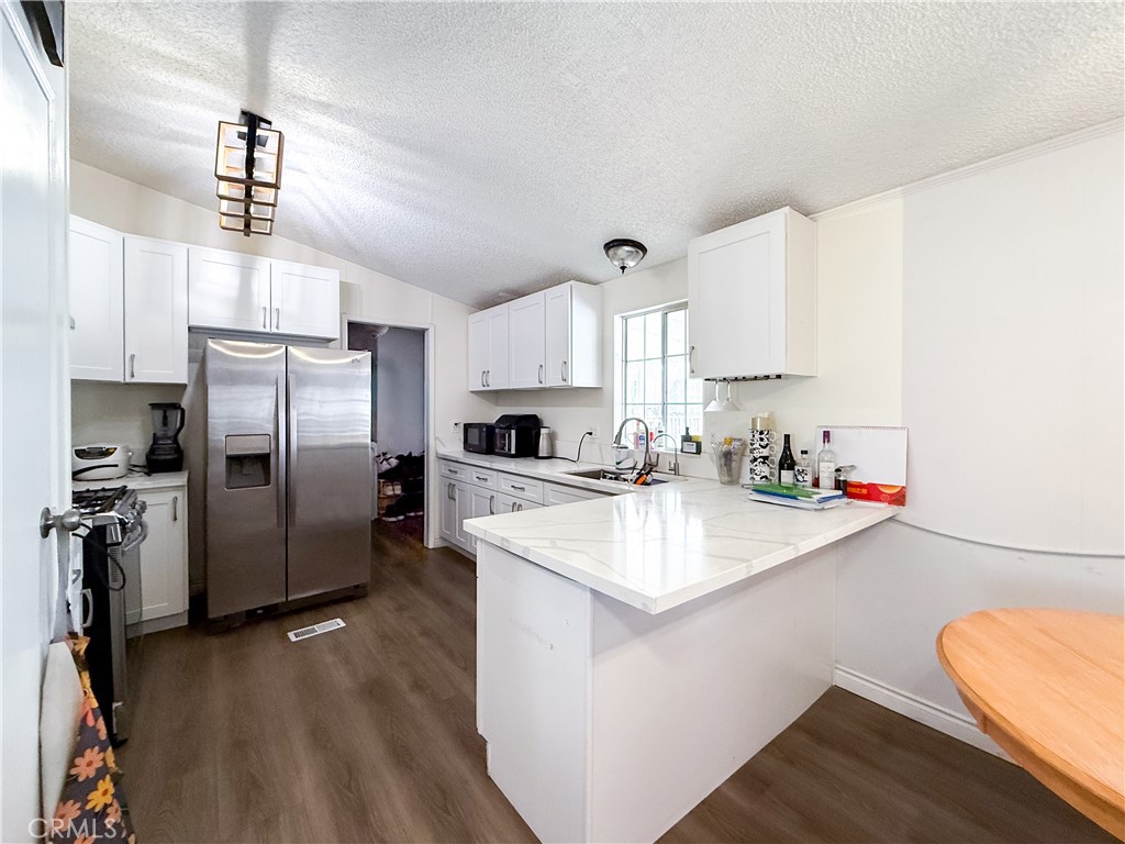 1855 East Riverside, Unit 130 Ontario, CA 91761 - Photo 21 of 62 a kitchen with stainless steel appliances a sink stove refrigerator and cabinets