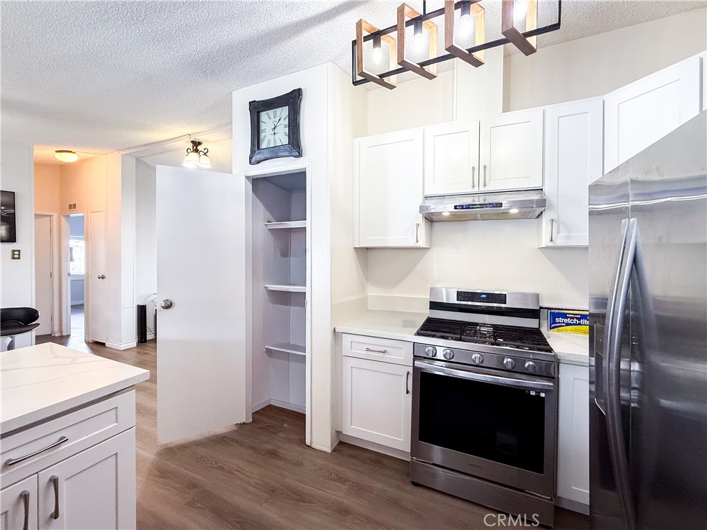 1855 East Riverside, Unit 130 Ontario, CA 91761 - Photo 26 of 62 a kitchen with stainless steel appliances a stove a sink and a refrigerator