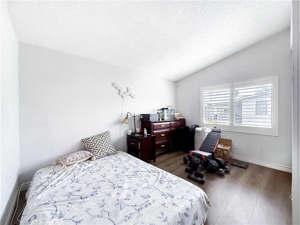 1855 East Riverside, Unit 130 Ontario, CA 91761 - Photo 32 of 62 a bedroom with a bed and wooden floor