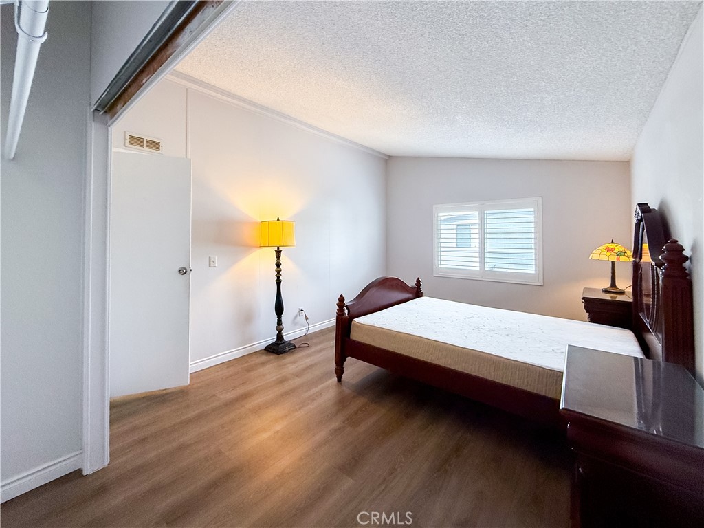 1855 East Riverside, Unit 130 Ontario, CA 91761 - Photo 37 of 62 a bedroom with a bed and wooden floor
