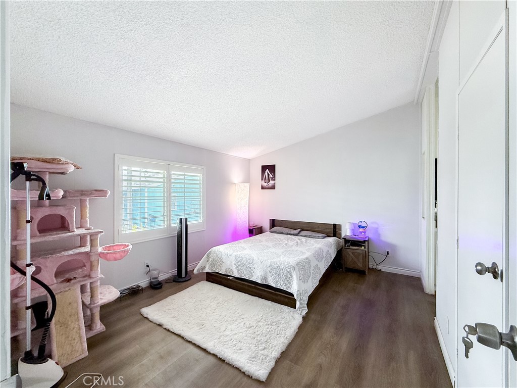1855 East Riverside, Unit 130 Ontario, CA 91761 - Photo 39 of 62 a bedroom with a bed and wooden floor