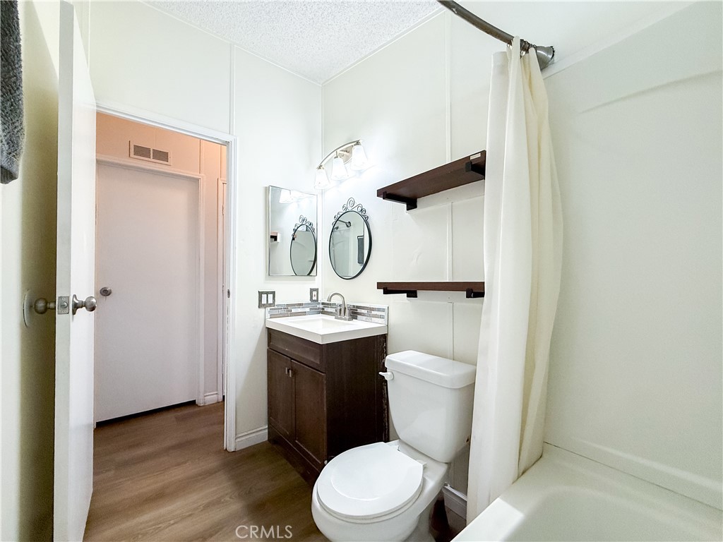 1855 East Riverside, Unit 130 Ontario, CA 91761 - Photo 46 of 62 a bathroom with a granite countertop toilet sink and a mirror