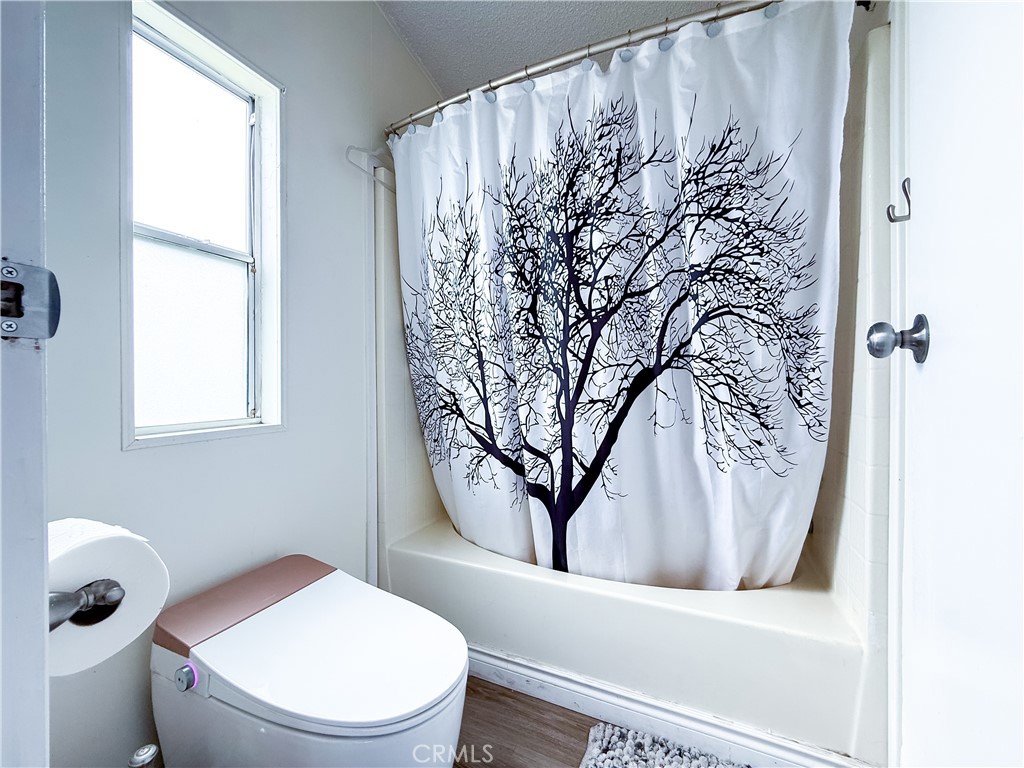 1855 East Riverside, Unit 130 Ontario, CA 91761 - Photo 51 of 62 a bathroom with a toilet and a shower curtain