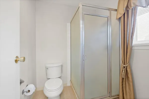 a bathroom with a granite countertop toilet a sink and a mirror