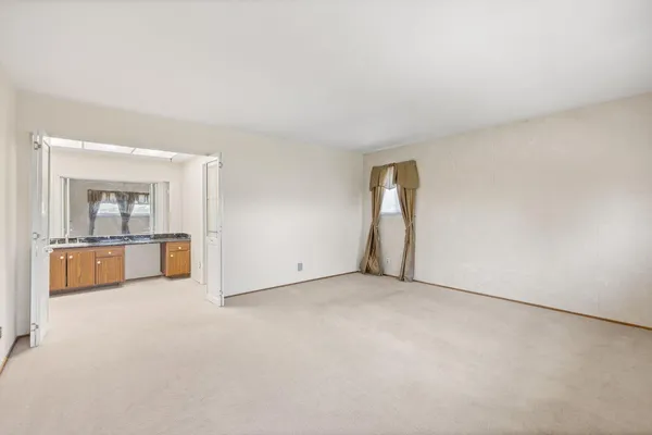 an empty room with cabinet and mirror