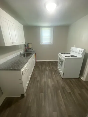 a utility room with wooden floor washer and dryer