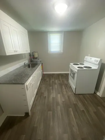 a utility room with wooden floor washer and dryer