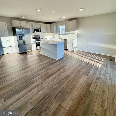 a view of kitchen with sink microwave and refrigerator