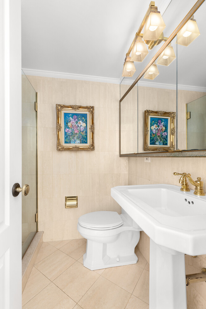 150 East 69th Street, Unit 11L Manhattan, NY 10021 - Photo 9 of 13 a bathroom with a sink a toilet and mirror