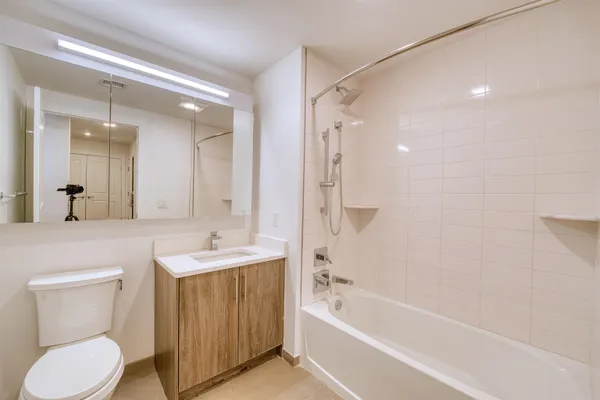 a bathroom with a sink toilet vanity and bathtub