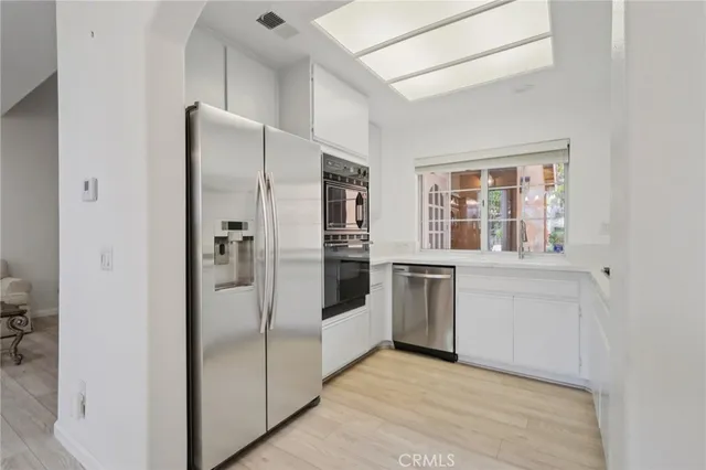 a kitchen with stainless steel appliances a refrigerator and cabinets