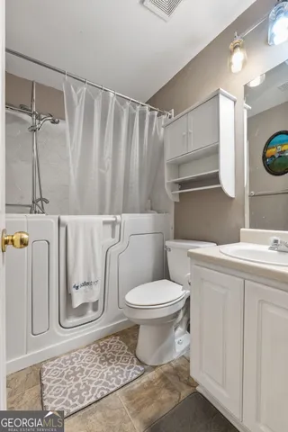 a bathroom with a toilet sink and shower