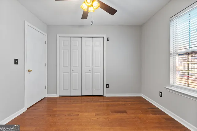 an empty room with closet and windows