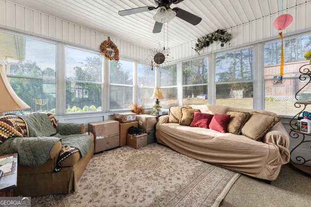 a living room with furniture ceiling fan and a large window