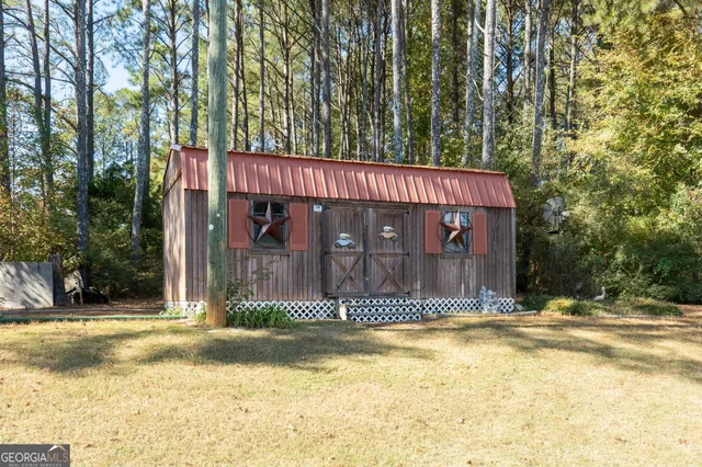 a view of a house with large trees and a small yard