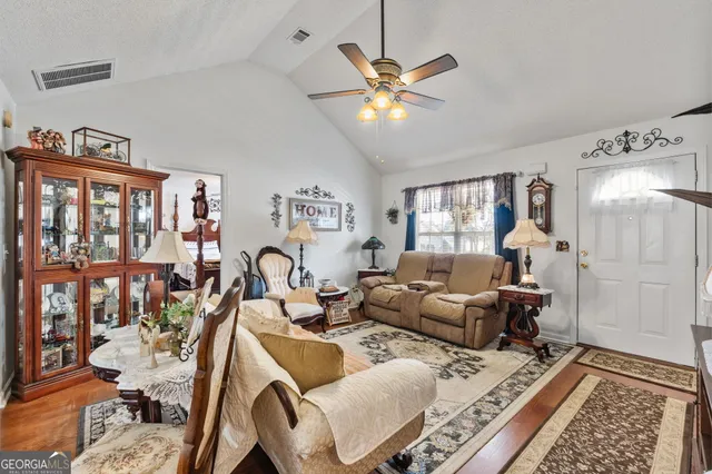 a living room with furniture a lamp and a rug