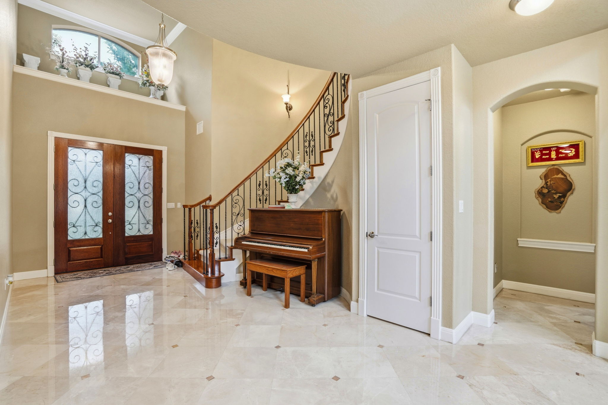222 Vailco Lane Austin, TX 78738 - Photo 5 of 39 Grand entryway featuring light-toned tile flooring with accent inlays and a curved staircase with wrought iron balusters