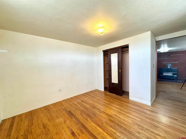 a view of empty room with wooden floor
