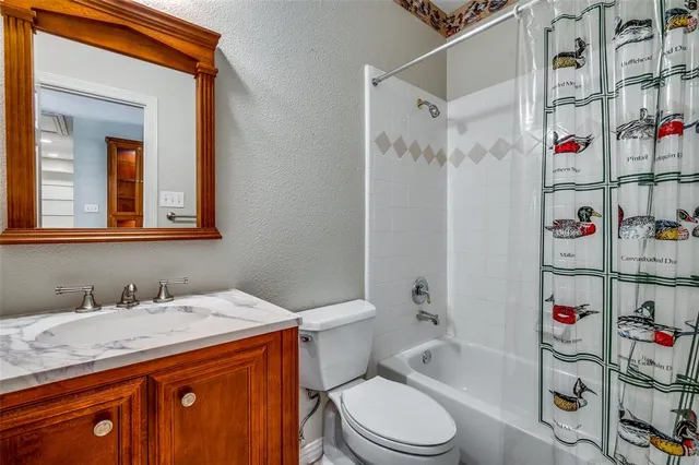 a spacious bedroom with a large bed a chandelier and windows