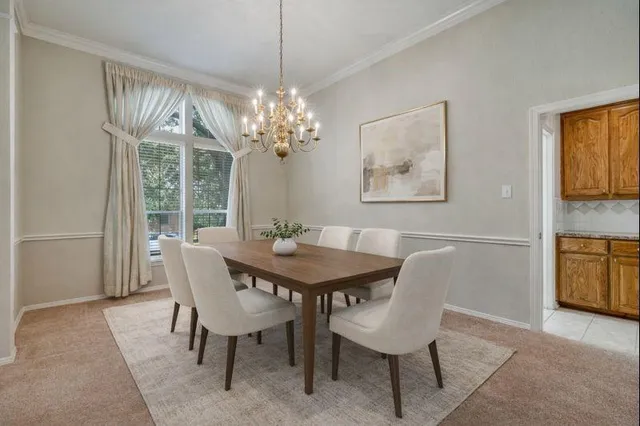 a view of a dining room with furniture and chandelier