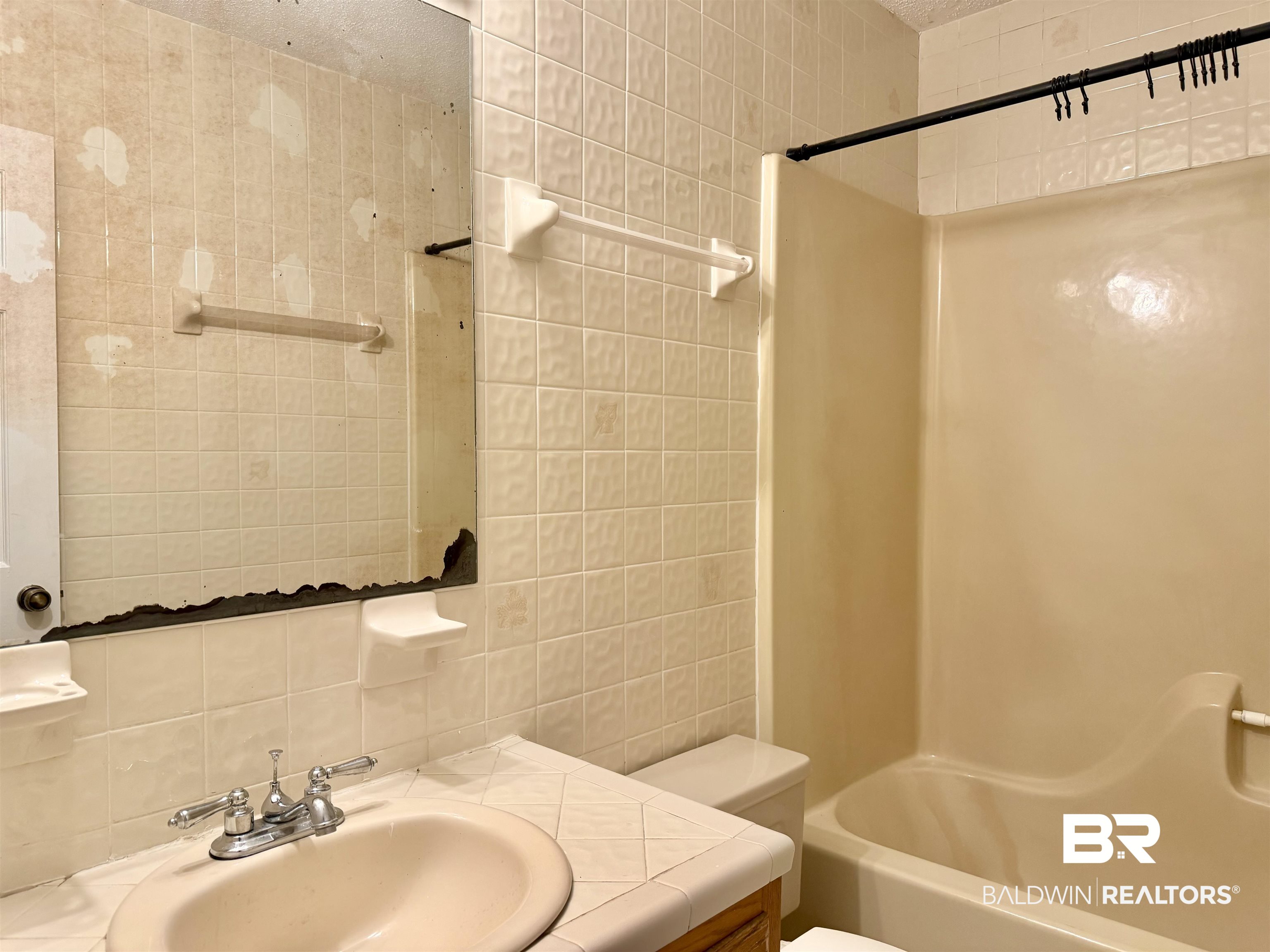 294 Wolf Log Road Flomaton, AL 36441 - Photo 12 of 14 Bathroom with tile walls, vanity, and shower / bath combo with shower curtain