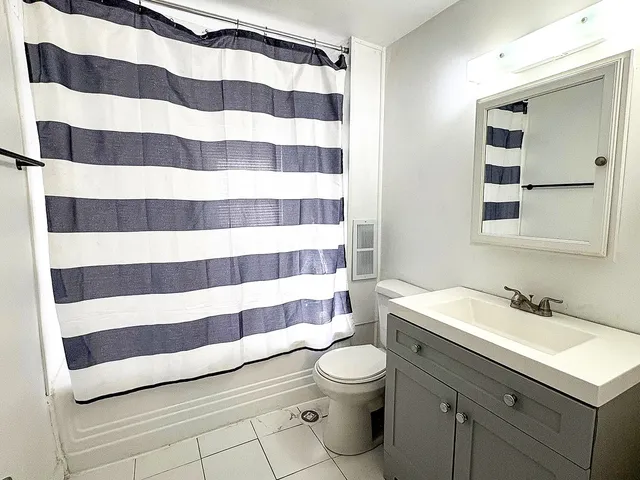 a bathroom with a sink a toilet a mirror and shower