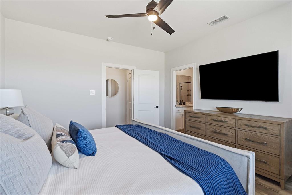 1012 Calhoun Drive Anna, TX 75409 - Photo 20 of 39 Bedroom featuring a ceiling fan with integrated lighting, light gray walls, and wood-finish flooring