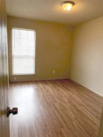 a view of a room with wooden floor and a ceiling fan