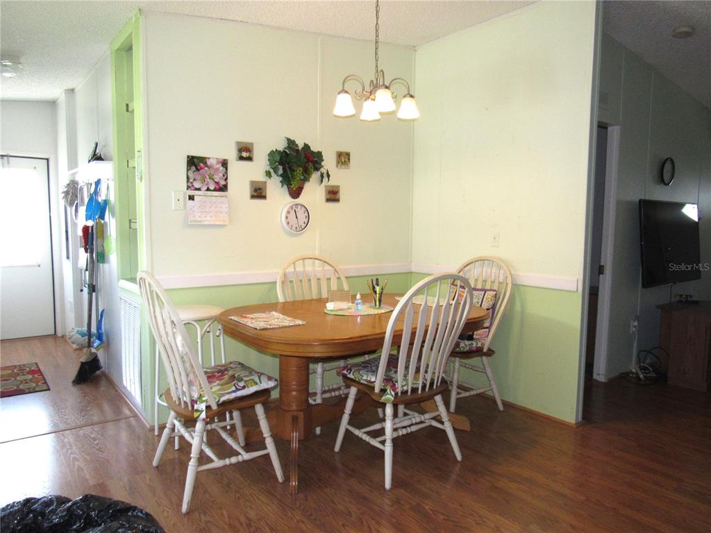 10101 Burnt Store Road, Unit 52 Punta Gorda, FL 33950 - Photo 11 of 37 a view of a dining room with furniture wooden floor and a chandelier