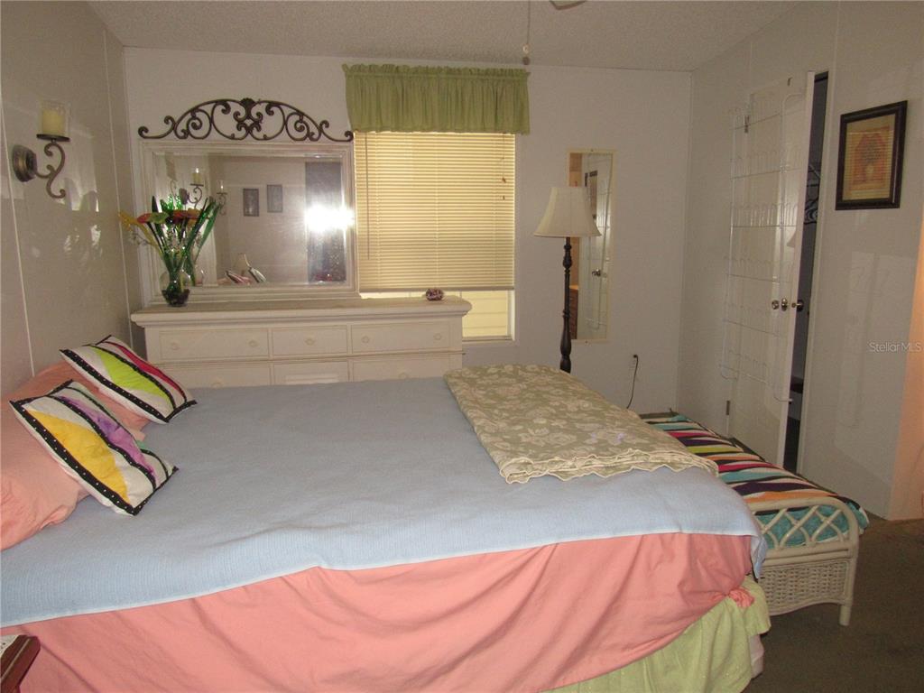 10101 Burnt Store Road, Unit 52 Punta Gorda, FL 33950 - Photo 12 of 37 a spacious bedroom with a bed and dresser