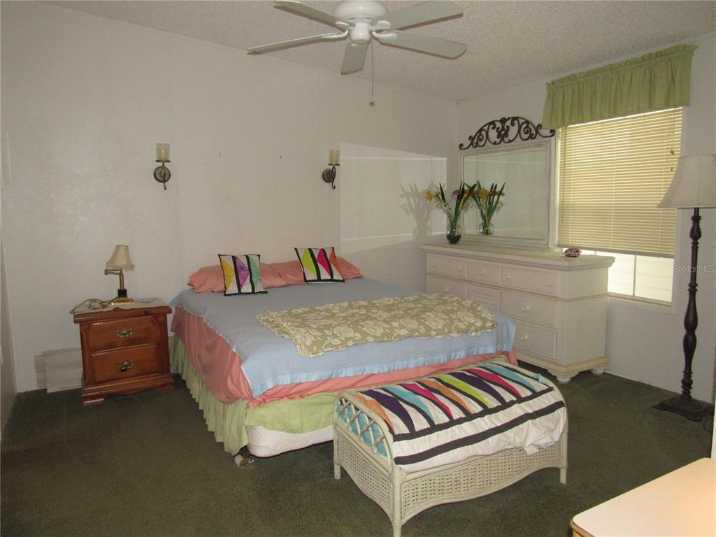 10101 Burnt Store Road, Unit 52 Punta Gorda, FL 33950 - Photo 14 of 37 a bedroom with a bed and a chandelier